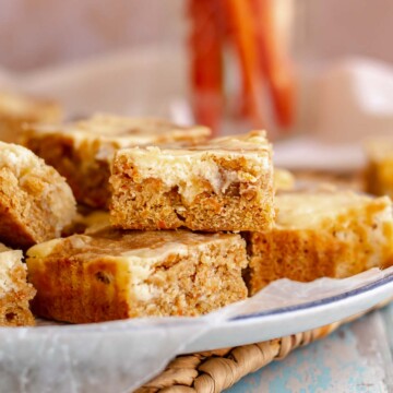 Carrot cake blondies stacked on a plate.