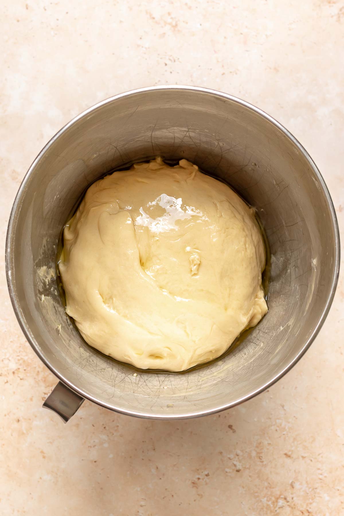 Kneaded dough covered in oil in a bowl.