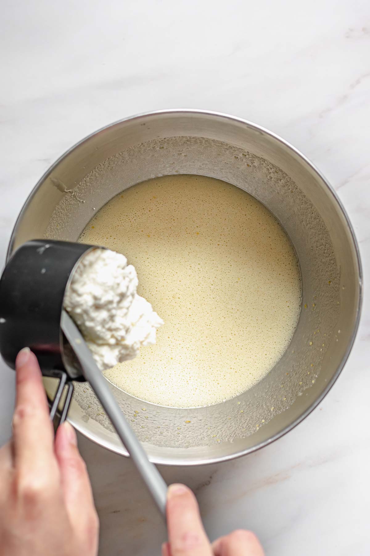 Ricotta being added to the batter.