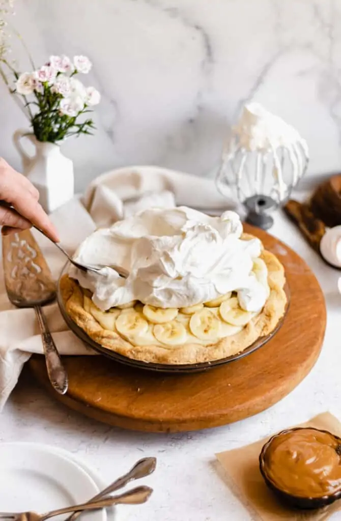 a large mound of whipped cream gets spread on top of the pie as the final layer