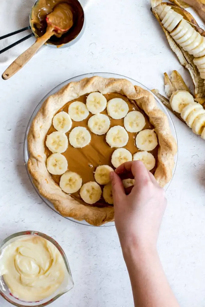 sliced bananas are getting layered on top of the dulce de leche