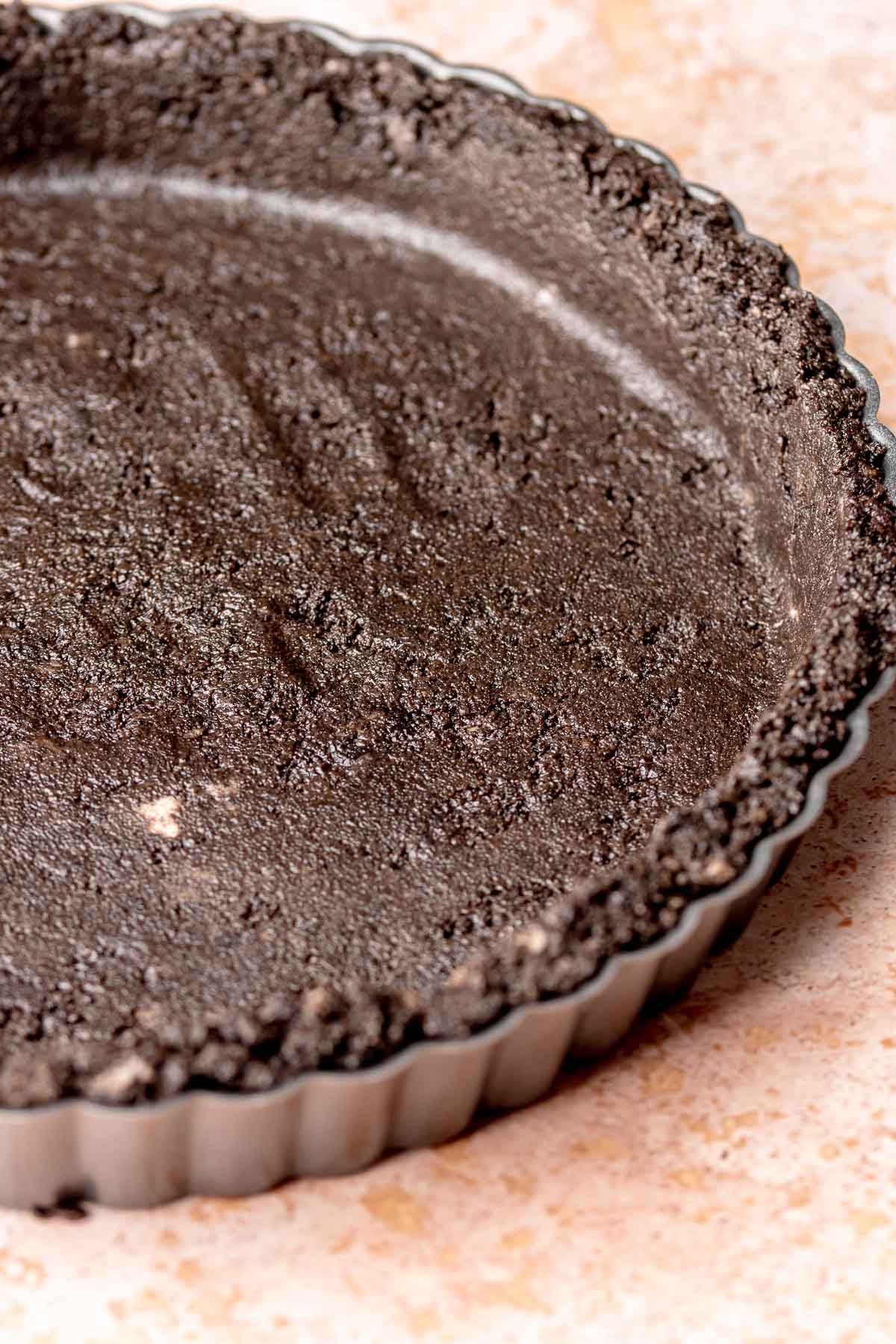 Oreo crust pressed into a tart pan.