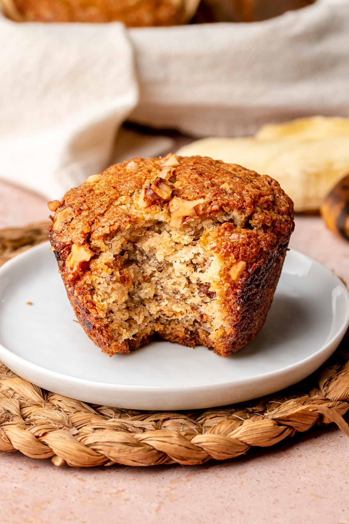 A banana muffin on a plate with a bite removed.