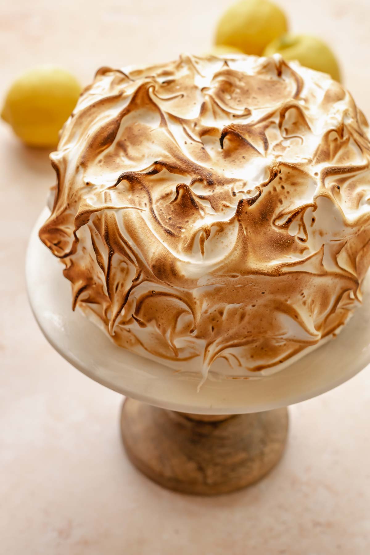 Torched lemon meringue cake on a cake stand.