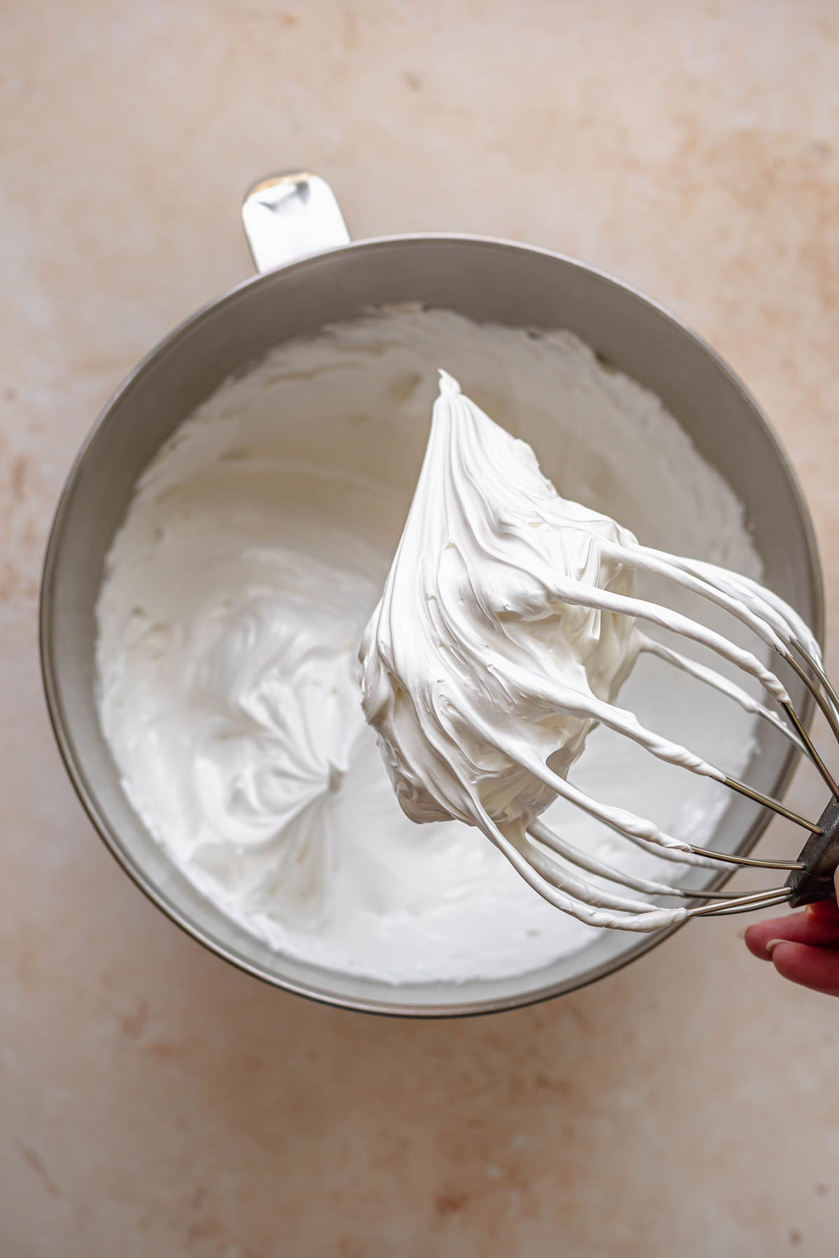 Whipped Swiss meringue on a whisk.