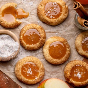 An array of caramel apple cider cookies on parchment paper.