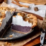 A slice of purple sweet potato pie in a pie dish.