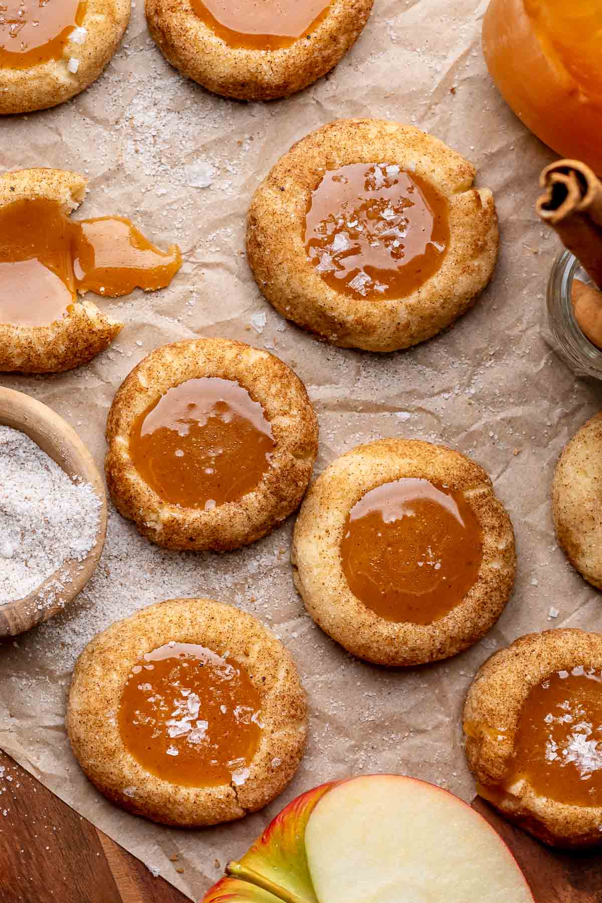 An array of caramel apple cider cookies on parchment paper.