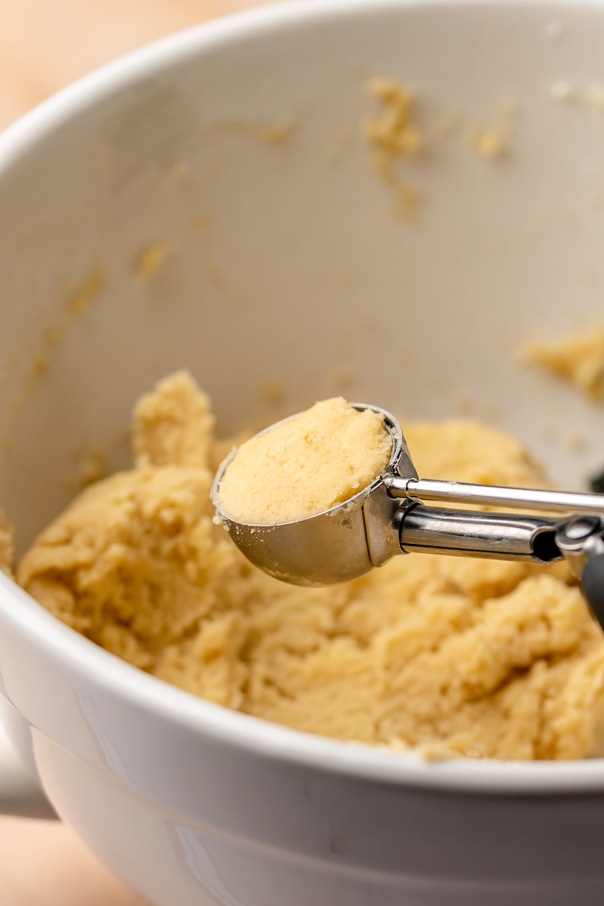 A cookie scoop holds cookie dough in the scoop.