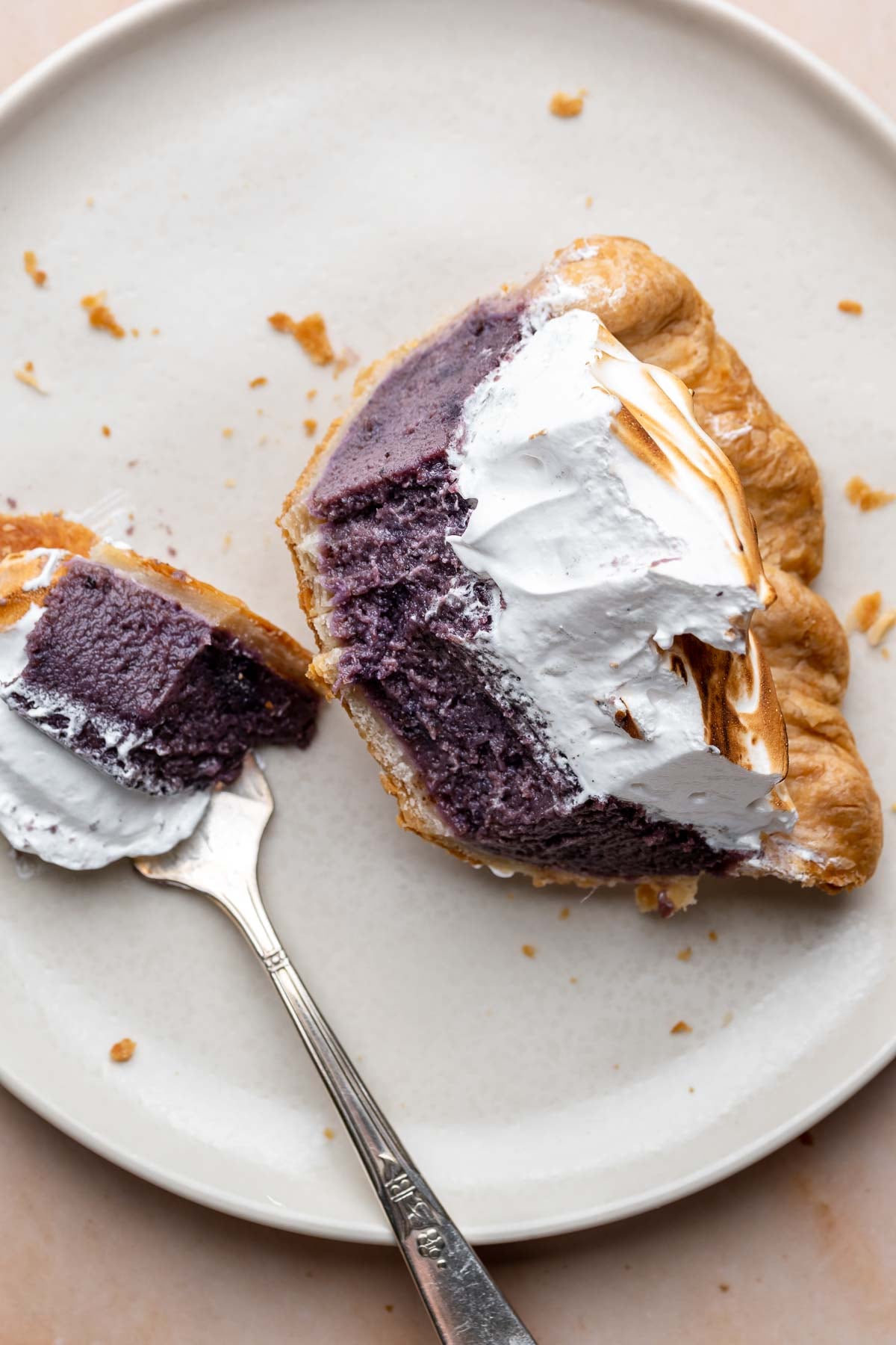 Purple sweet potato pie half eaten on a plate with a fork.