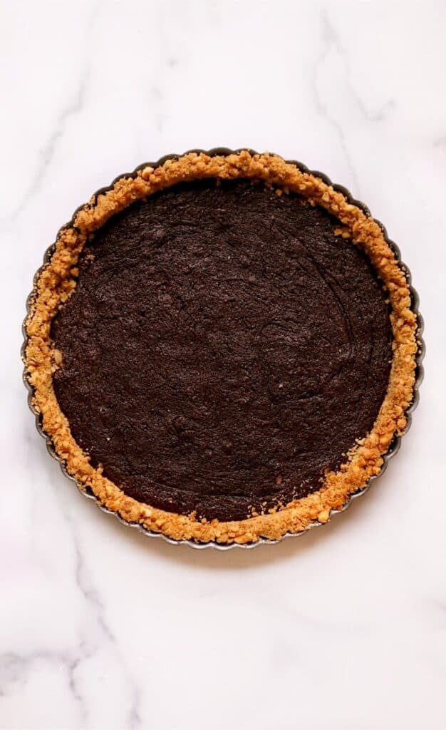 Overhead shot of the baked brownie layer in the pretzel crust