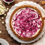 White chocolate tart with cranberries and white chocolate on the sides.