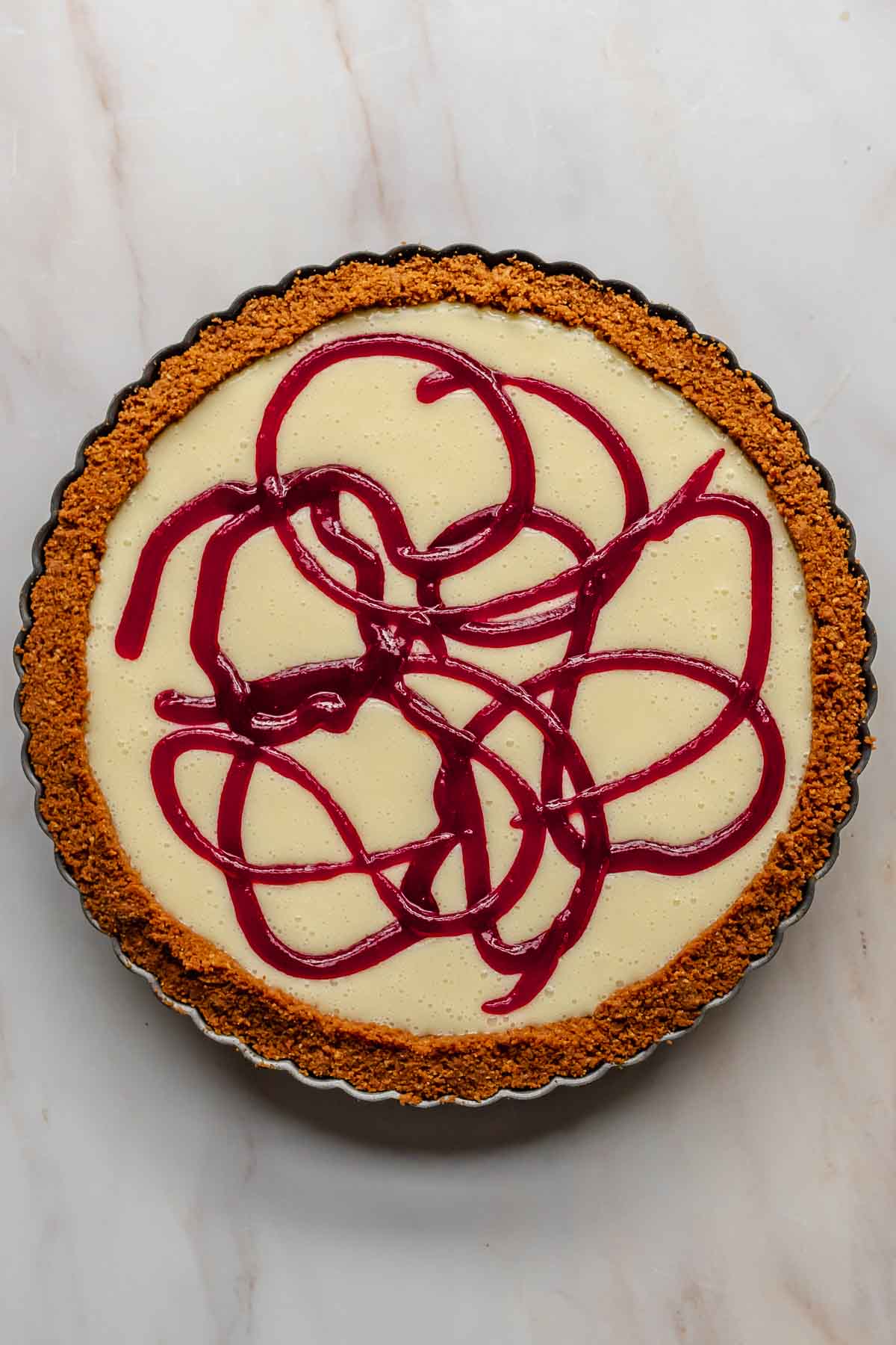 Cranberry swirls piped into the top of white chocolate tart.