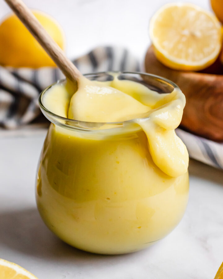 Lemon curd in a jar, spilling over the side