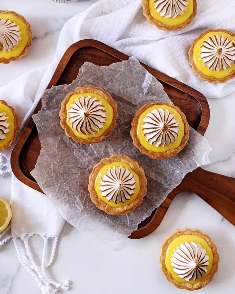 Overhead shot of multiple lemon meringue tartlets with torched tops.