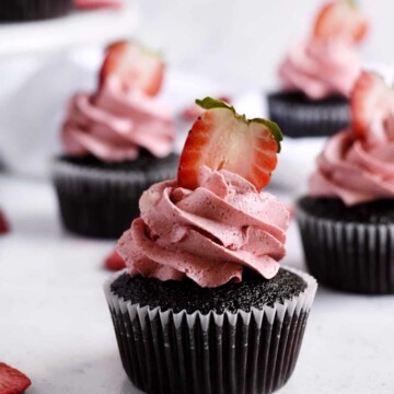 Close up photo of one double chocolate strawberry cupcake with a fresh strawberry on top.