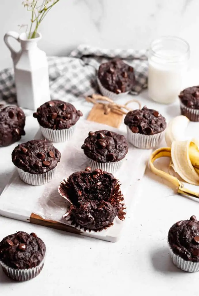 One double chocolate banana muffin is torn open to show the melted chocolate chips. 
