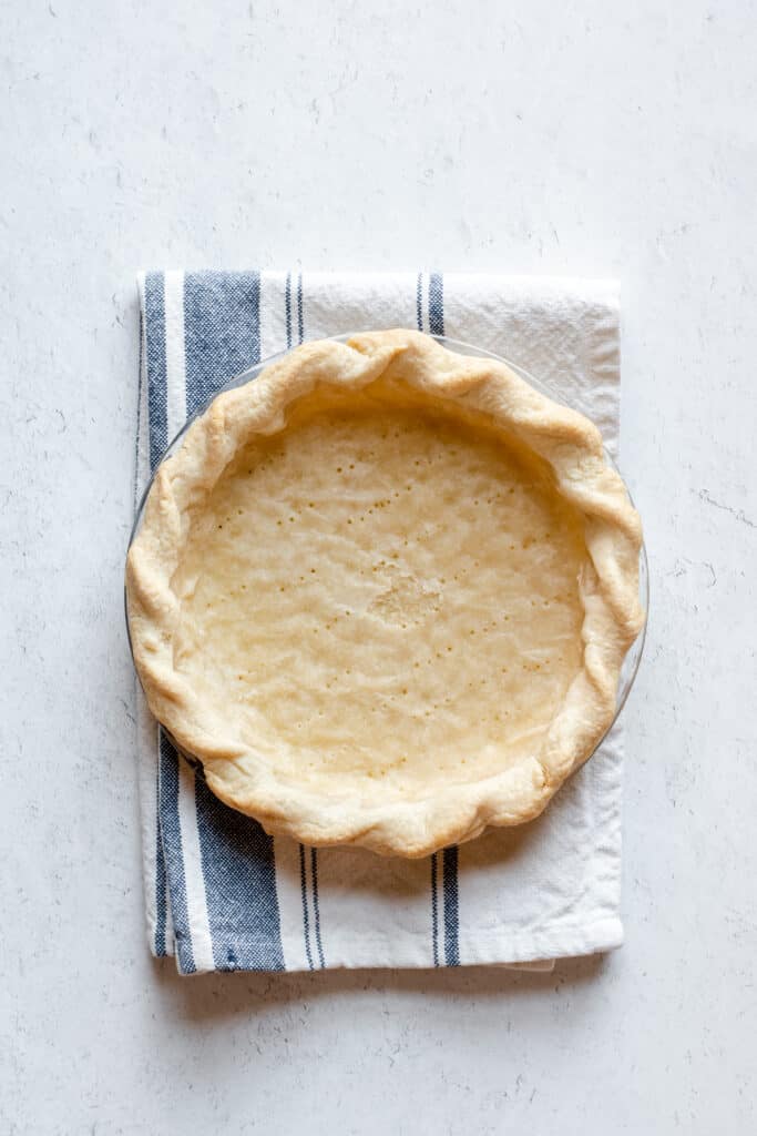 A par-baked pie crust, showing the bottom is still slightly moist.