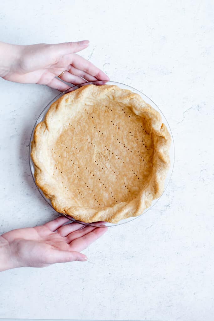 A blind baked pie crust, showing the bottom is fully baked.