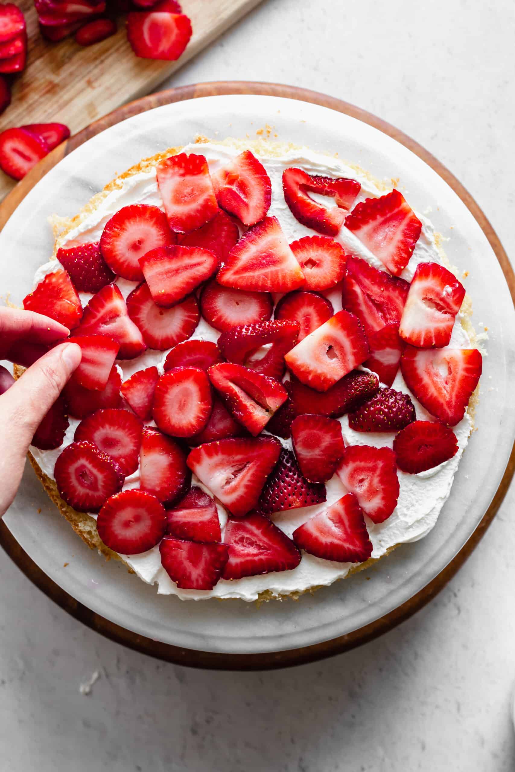Freshly sliced strawberries are added to the layer of whipped cream.