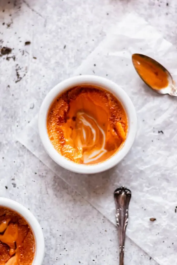 One single Thai tea creme brulee ramekin from above. Bites are remove to show the creaminess.