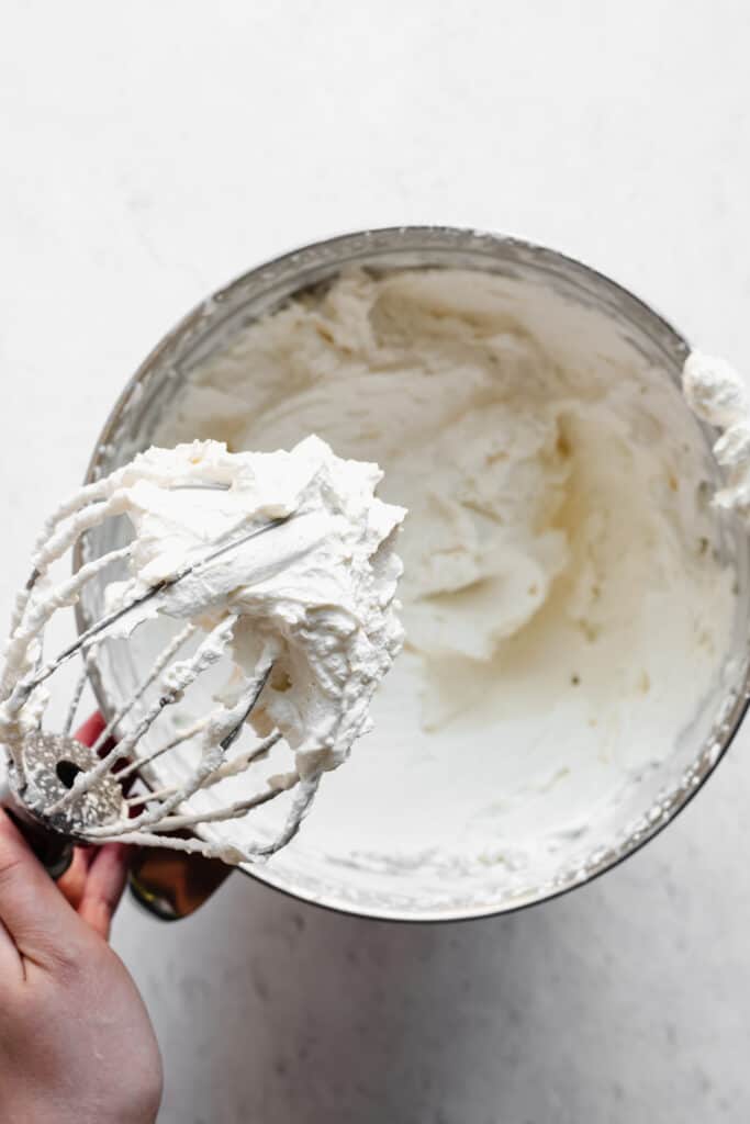 Stiff peaks of whipped cream on a whisk