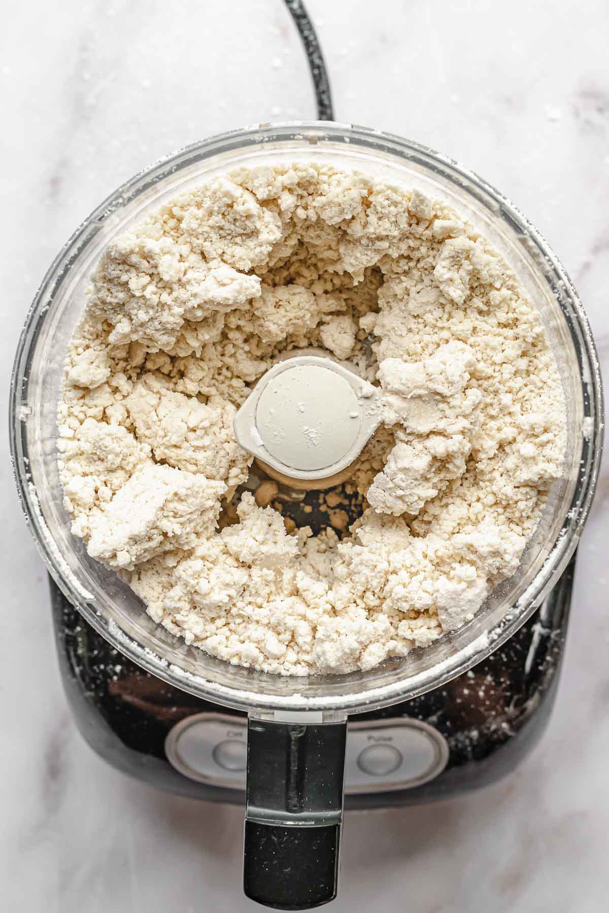 Crumbly pie dough in a food processor.