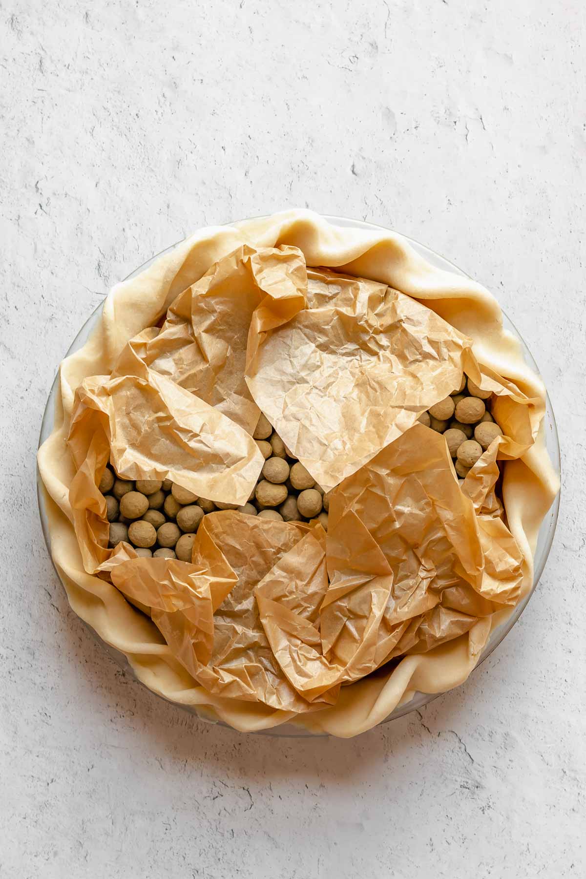 Parchment paper and weights in a pie crust.