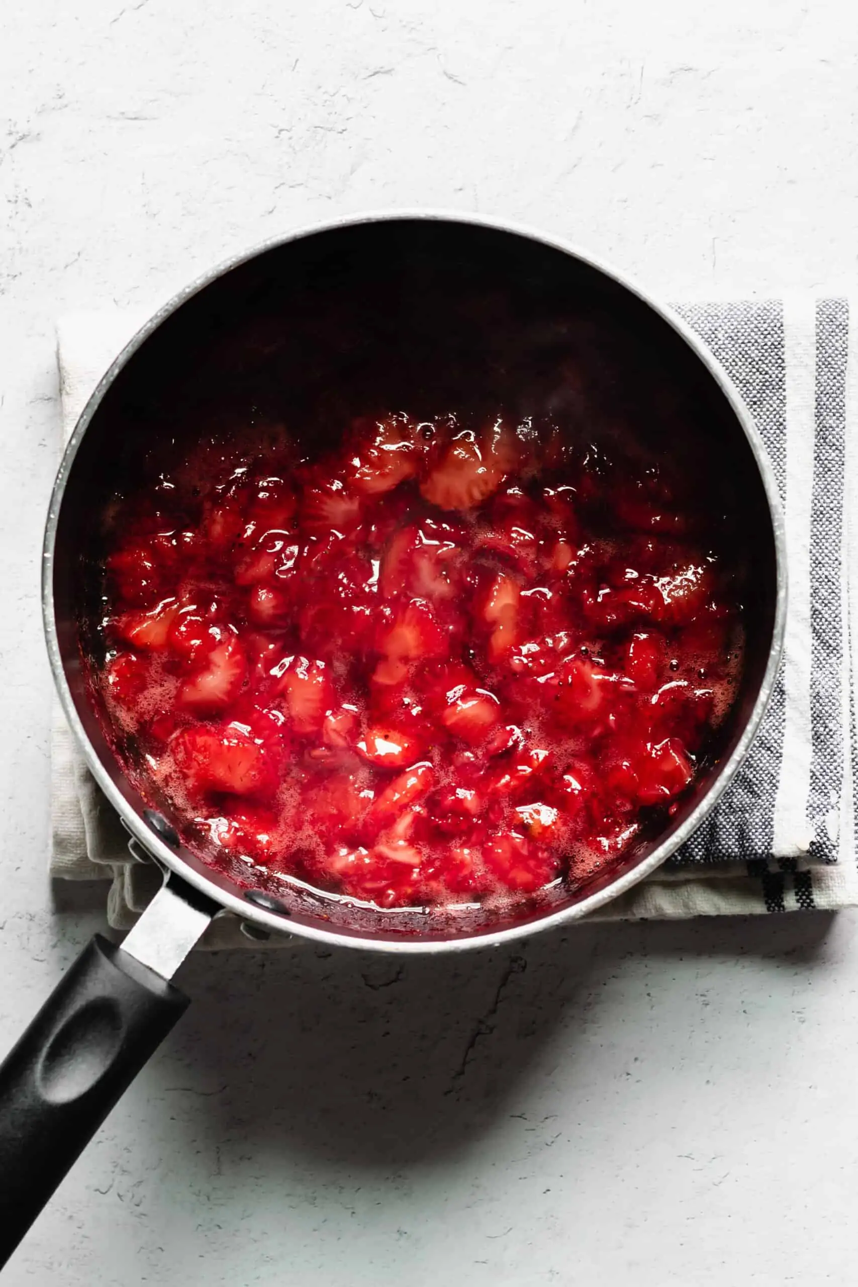 Cut strawberries and sugar in a saucepan cooking down.