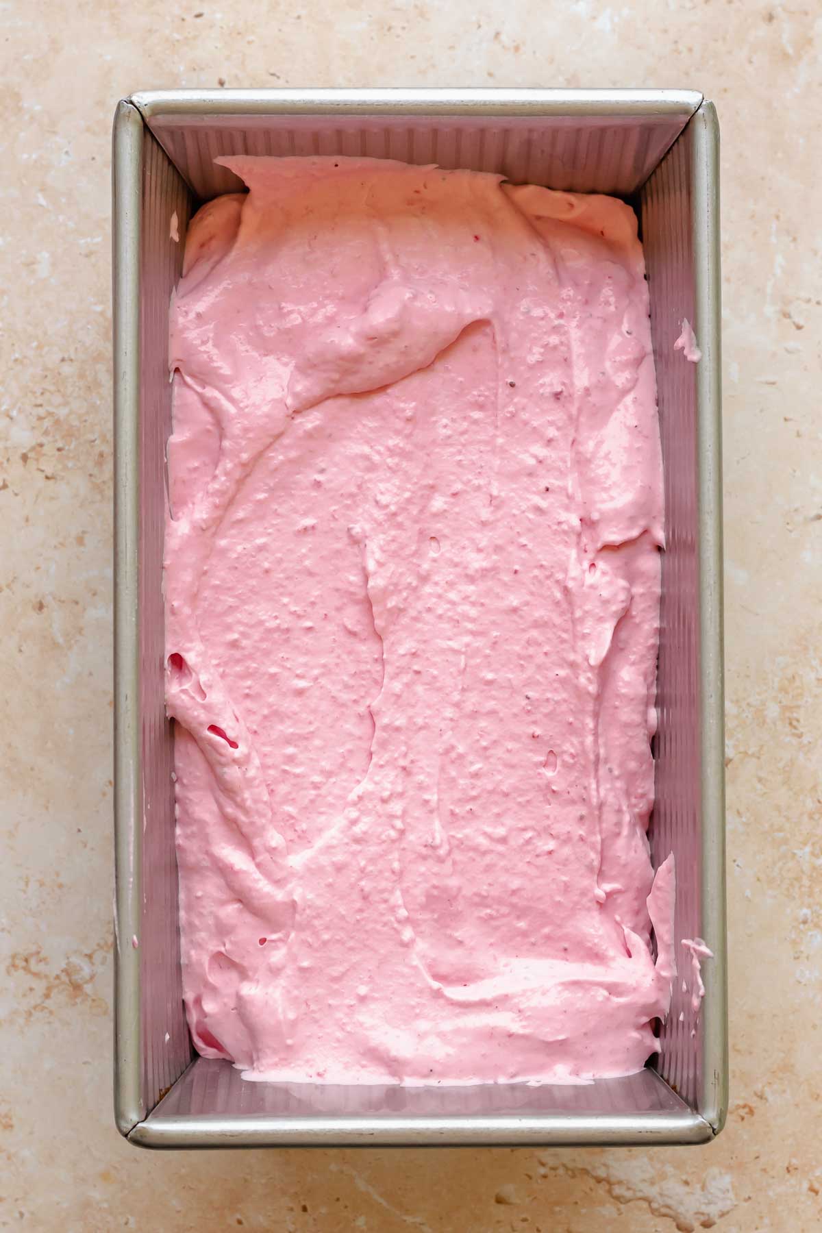 Strawberry ice cream in a loaf pan.