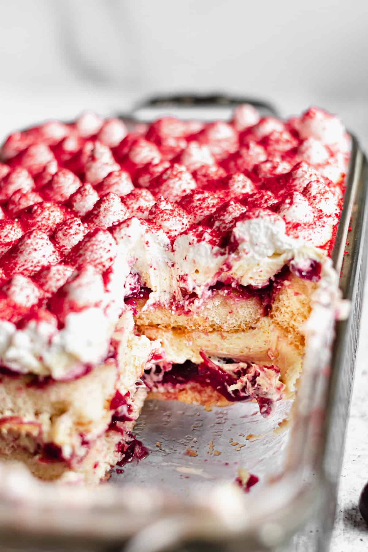 Sliced cherry almond tiramisue with pieces removed.