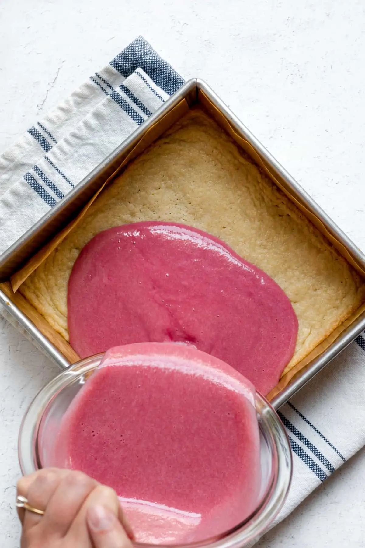 Rhubarb curd being poured on top of the par-baked shortbread crust