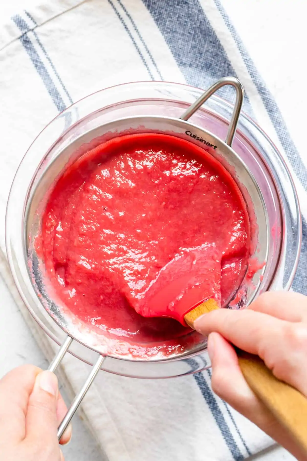 Rhubarb curd being passed through a fine mesh sieve