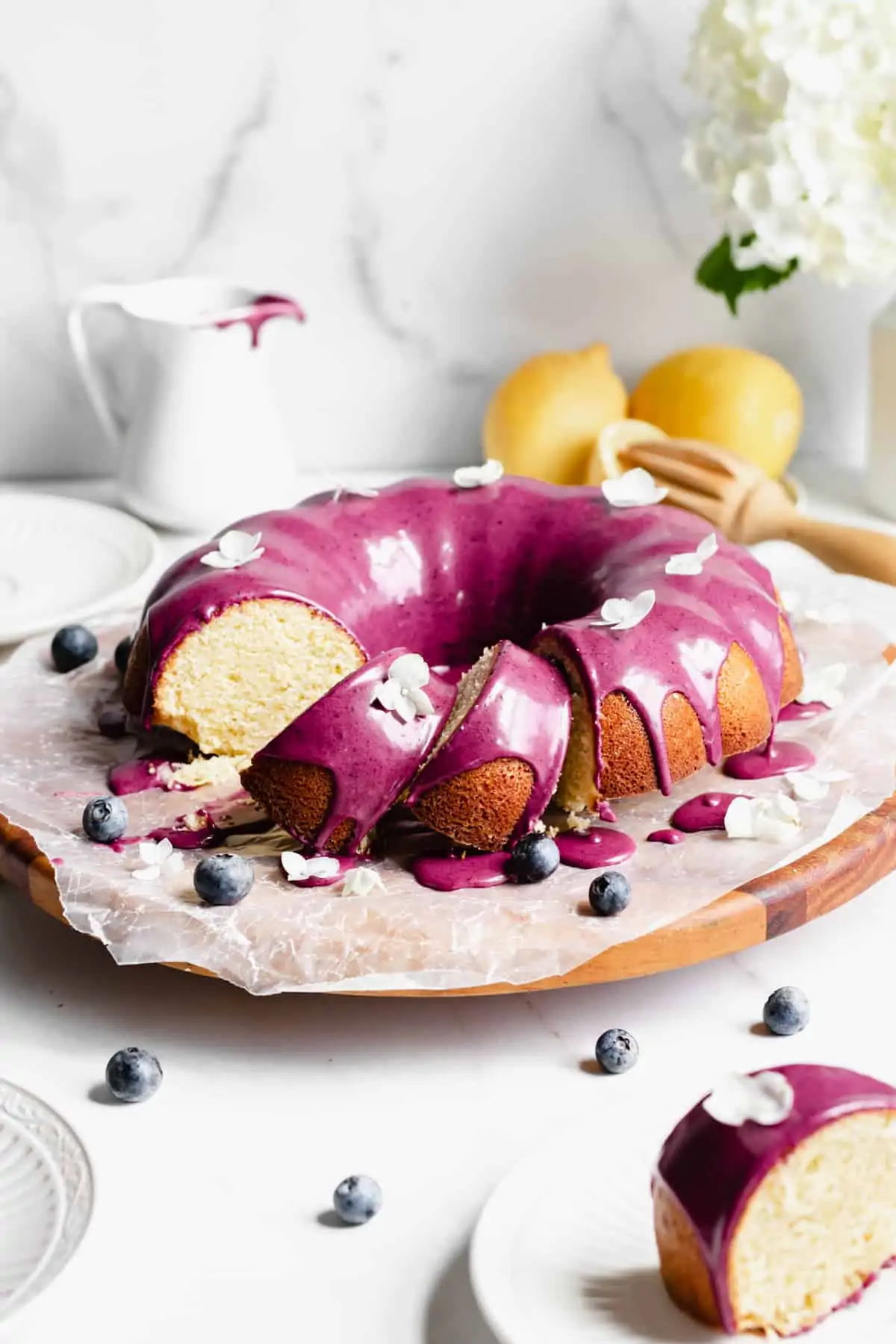 Lemon pound cake on a platter with a few slices leaning over.