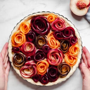 Completed stone fruit tart with roses shot from overhead.