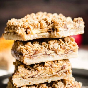 Stack of apple crisp bars with a bite removed from the top square.