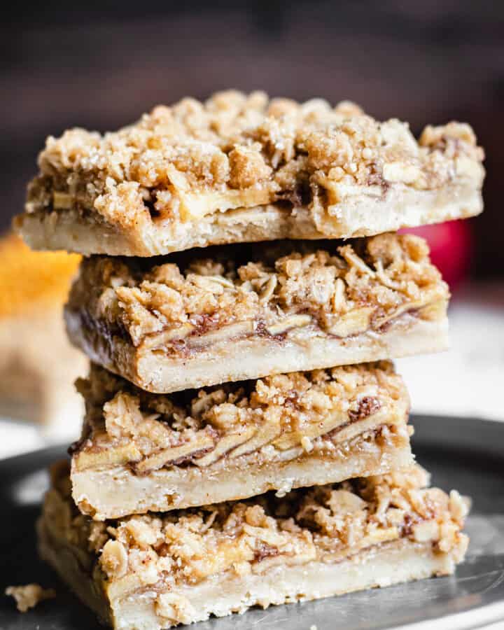 Stack of apple crisp bars with a bite removed from the top square