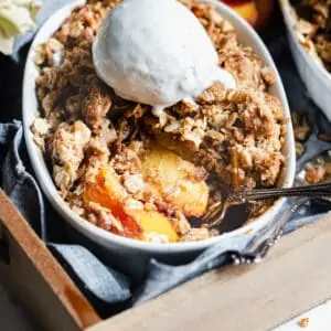 Peach crisp with a spoon in the dish ready to remove peach slices