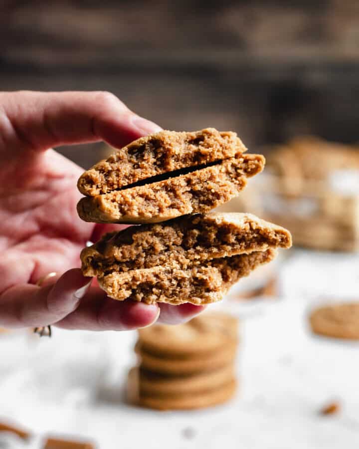 Two cookie butter cookies split in half being held by a hand.