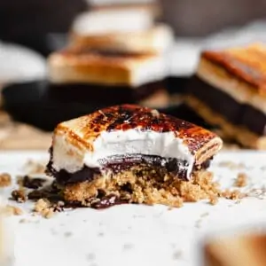 Smores bar with a bite removed and crumbs scattered
