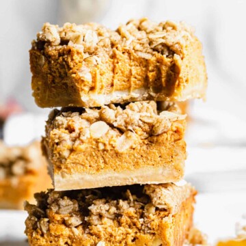 stack of pumpkin pie crumble bars. A bite is removed from the top bar.