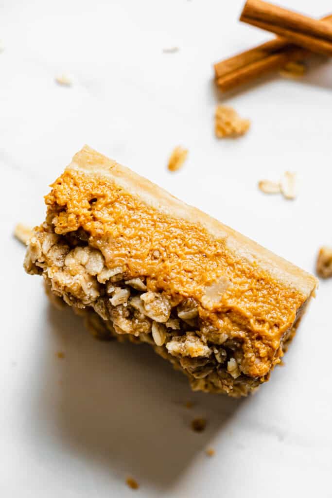one piece of pumpkin pie crumble bar sits on its side to expose the texture.