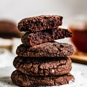 Stack of chocolate chai snickerdoodles. the top cookie is cut in half to expose the inside