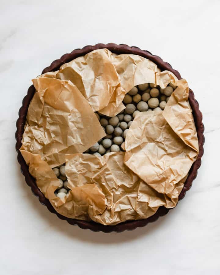 Parchment is folded onto the pie weights