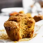 Straight on shot of a jumbo pumpkin muffin with a bite removed