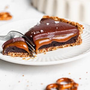 Slice of caramel brownie pie with a fork removing the tip