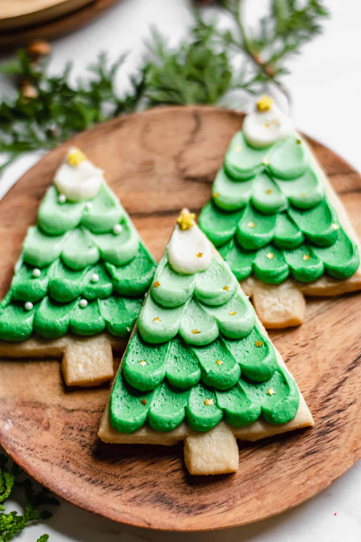 Three Christmas Shortbread Cookies on a wooden plate