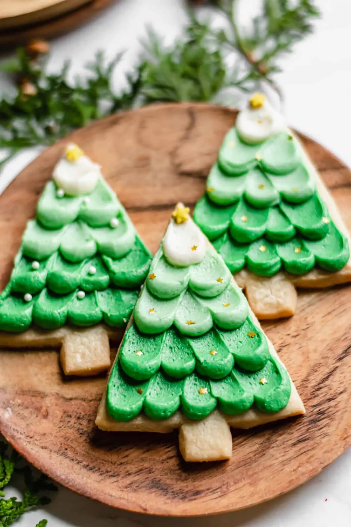 Three Christmas Shortbread Cookies on a wooden plate