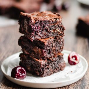 Stack of three cut brownies to expose the cherries inside