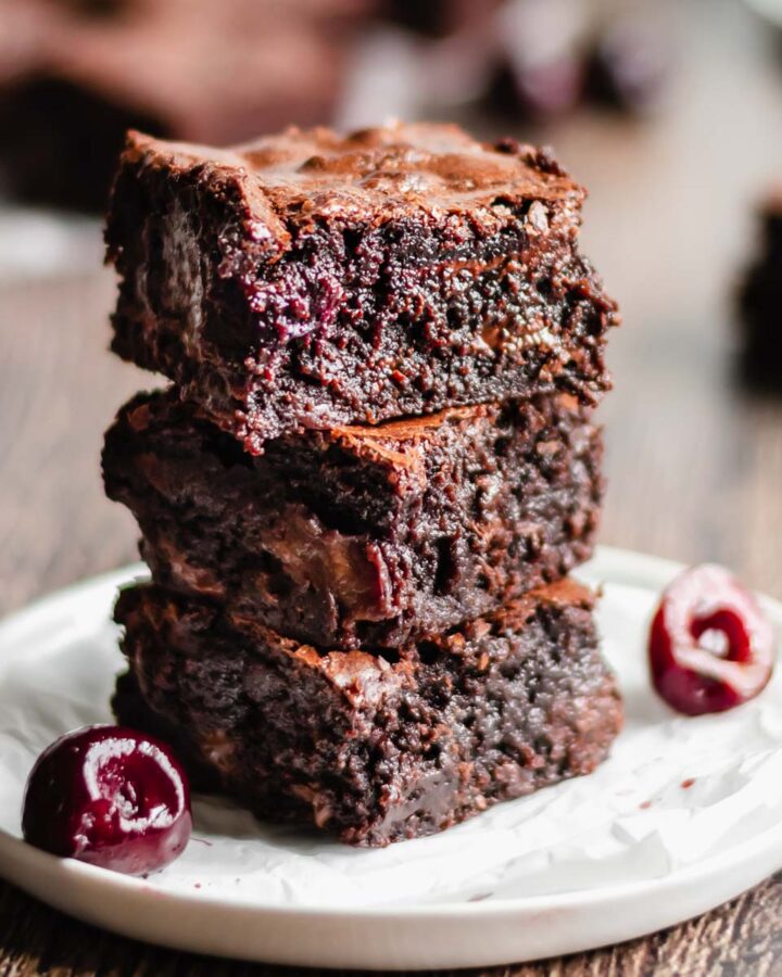 Stack of three cut brownies to expose the cherries inside